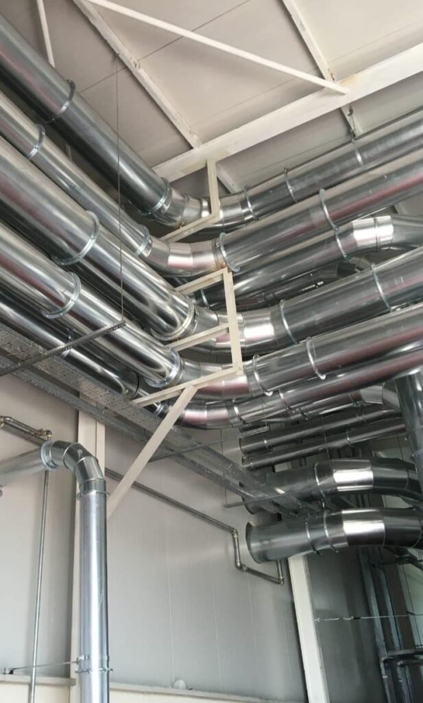 Endüstriyel tesiste montajı yapılmış flanşlı akış boruları – havalandırma ve toz transfer hattı uygulaması